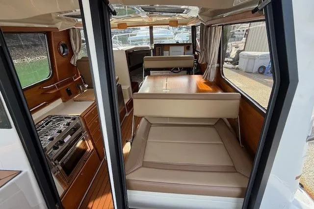 Slide: The Image of Interior of 2023 Ranger Tugs R-27 boat, featuring kitchen and seating area. - 7