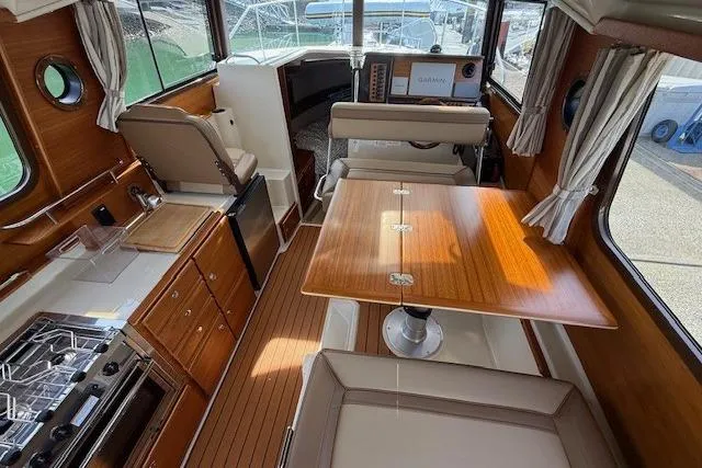 Slide: The Image of Interior of 2023 Ranger Tugs R-27 boat with wood finishes and modern amenities. - 8