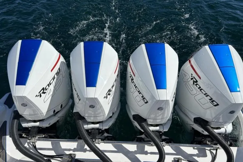 Slide: The Image of Four powerful outboard motors on a 2023 Fountain 43 NX boat, racing through water. - 11