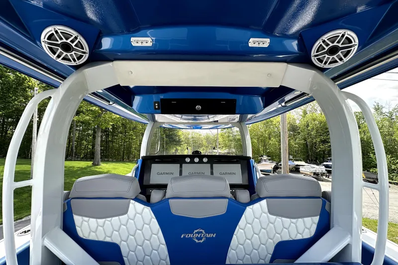 Slide: The Image of 2023 Fountain 43 NX boat interior with blue and white seating, advanced Garmin navigation. - 14