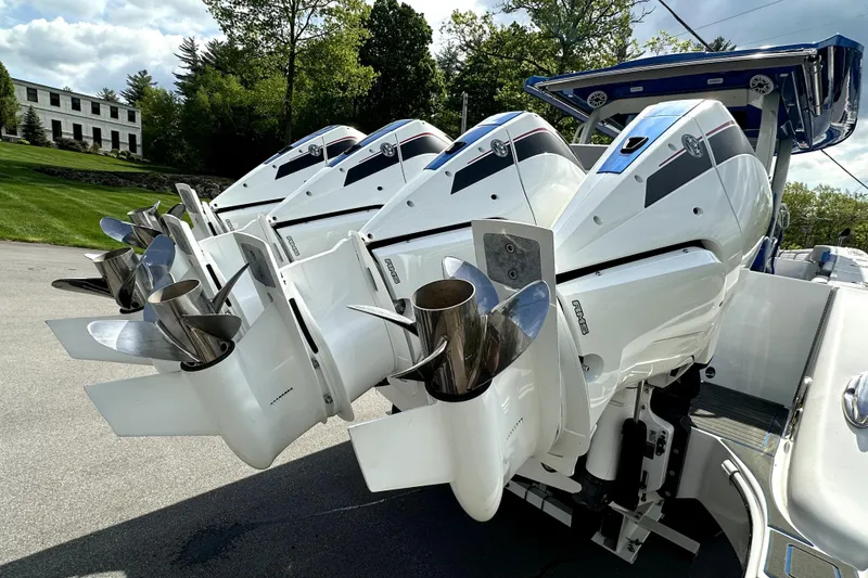 Slide: The Image of Four powerful outboard engines on a 2023 Fountain 43 NX boat, parked outdoors. - 22