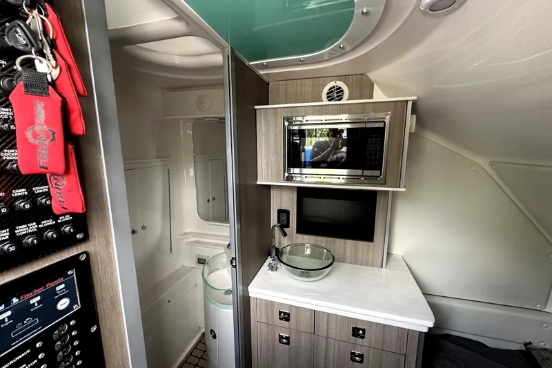 Slide: The Image of 2023 Fountain 43 NX interior with modern kitchenette, featuring microwave and sink. - 25