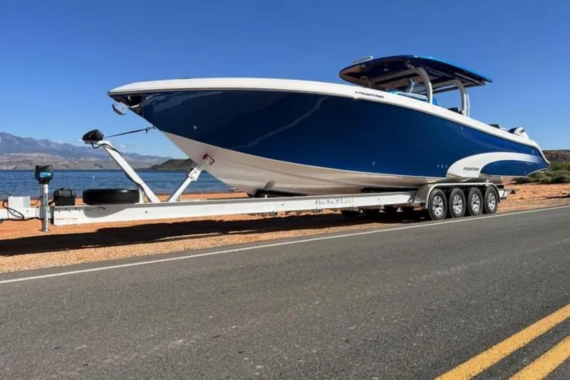 Slide: The Image of 2023 Fountain 43 NX boat on trailer by a scenic lake. - 3