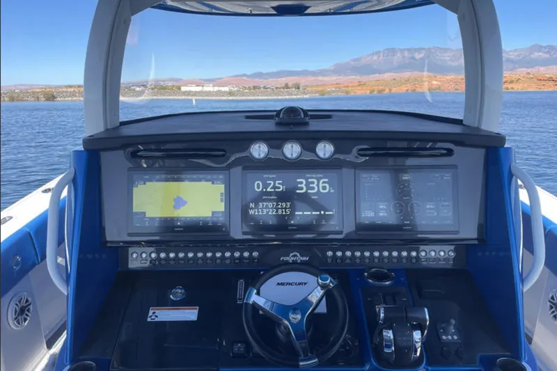 Slide: The Image of 2023 Fountain 43 NX boat dashboard with navigation screens and controls on a lake. - 6