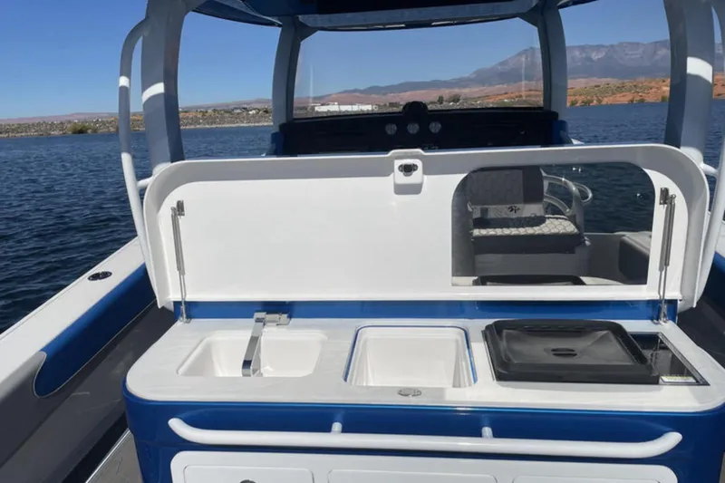 Slide: The Image of 2023 Fountain 43 NX boat with open deck kitchen on a serene lake. - 9