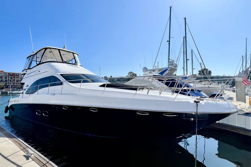 The Image of 2007 Sea Ray 58 Sedan Bridge yacht docked in marina under clear blue sky. - 0