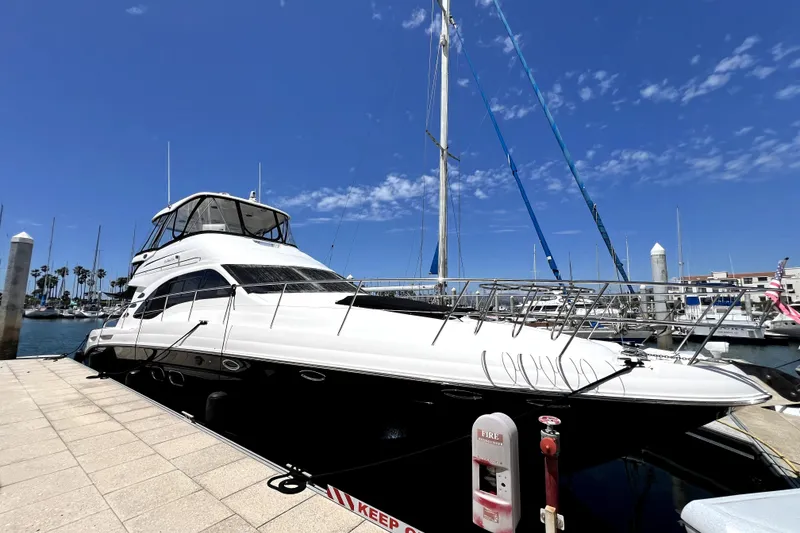 The Image of 2007 Sea Ray 580 Sedan Bridge yacht docked at marina under clear blue sky. - 1