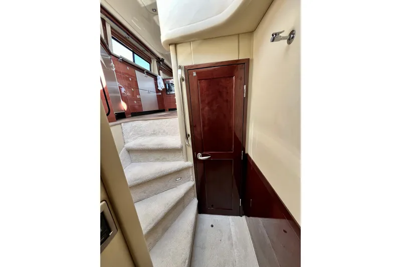 Slide: The Image of Interior view of 2007 Sea Ray 58 Sedan Bridge, featuring carpeted stairs and wooden cabinetry. - 100