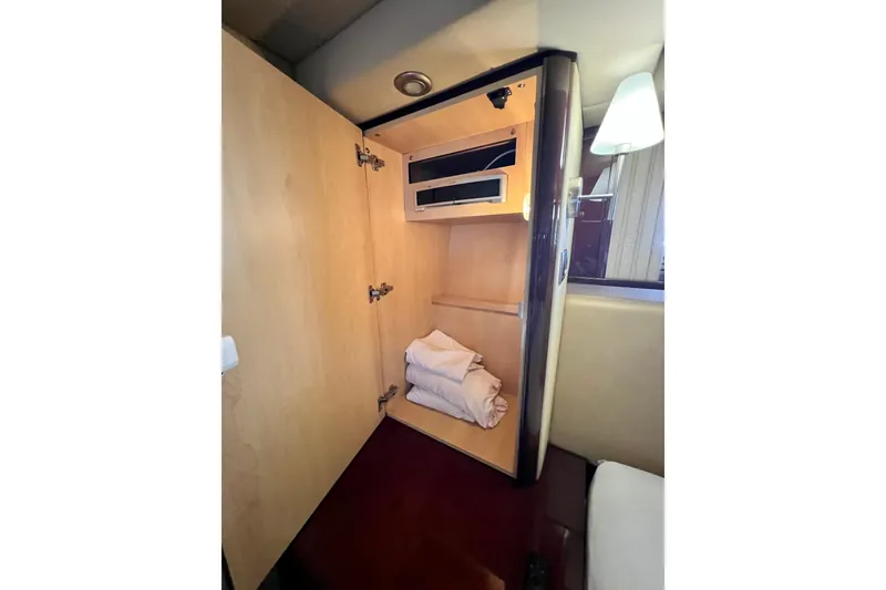 Slide: The Image of Open wooden cabinet with folded towels inside a 2007 Sea Ray 58 Sedan Bridge yacht. - 104