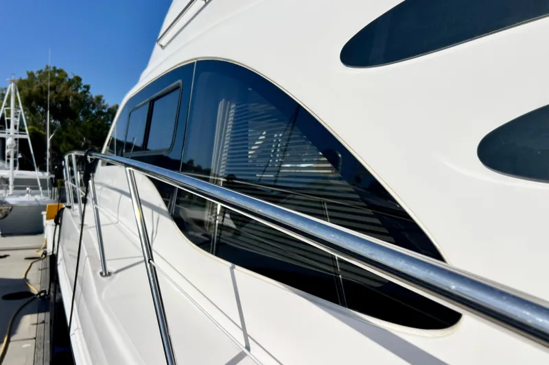 Slide: The Image of 2007 Sea Ray 58 Sedan Bridge yacht with sleek design and reflective windows. - 25