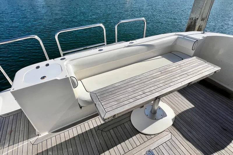 Slide: The Image of 2007 Sea Ray 58 Sedan Bridge yacht deck with seating and wooden table. - 31