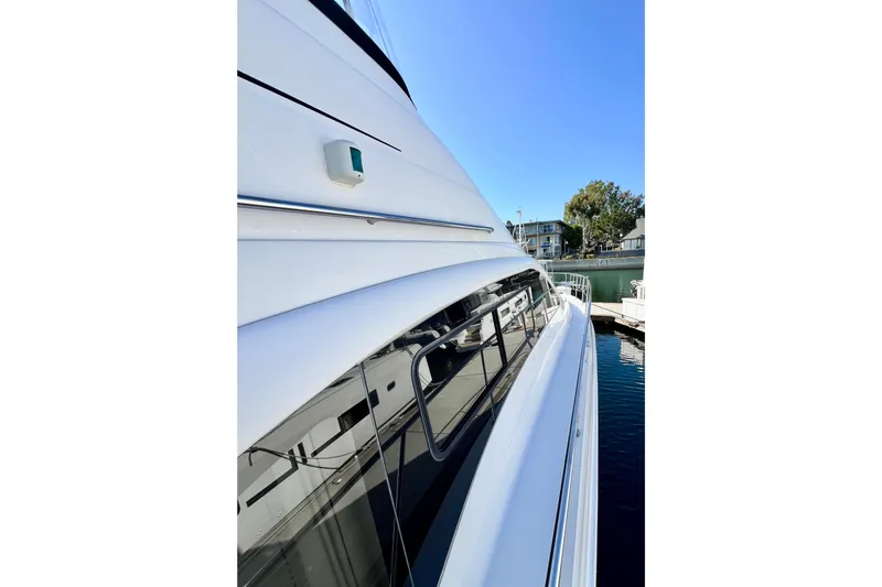 Slide: The Image of 2007 Sea Ray 58 Sedan Bridge yacht docked, showcasing sleek design and reflective windows. - 38