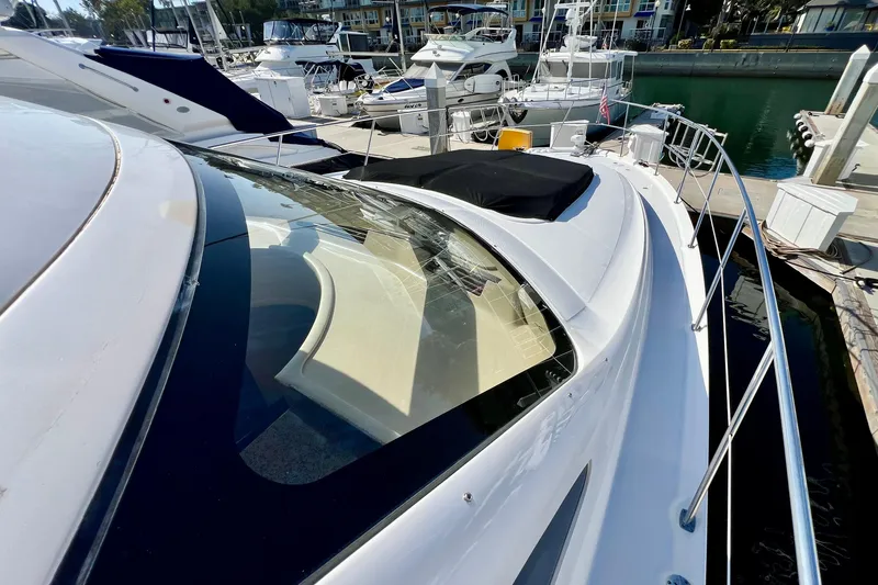 Slide: The Image of 2007 Sea Ray 58 Sedan Bridge yacht docked at marina, showcasing sleek design and spacious deck. - 39