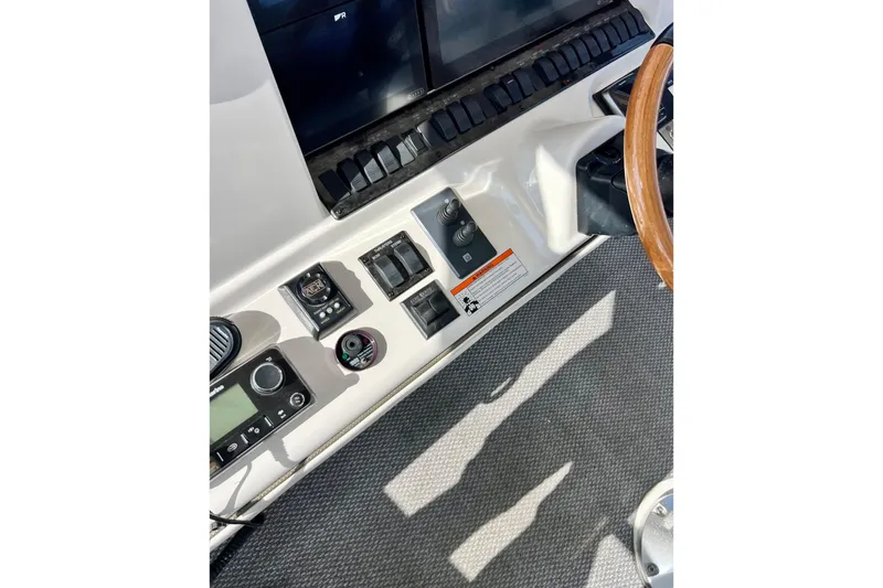 Slide: The Image of 2007 Sea Ray 58 Sedan Bridge helm controls with steering wheel and navigation instruments. - 52