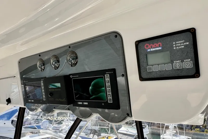 Slide: The Image of Control panel of a 2007 Sea Ray 58 Sedan Bridge yacht, featuring gauges and Onan e-Series display. - 56