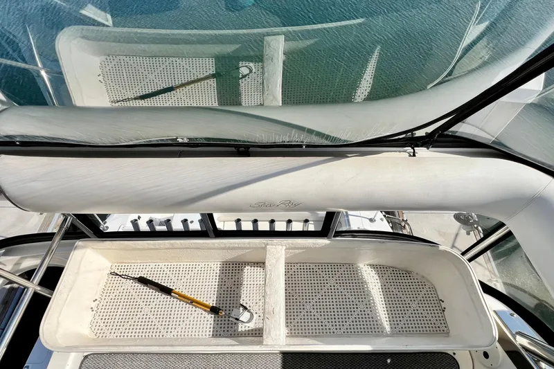 Slide: The Image of 2007 Sea Ray 58 Sedan Bridge cockpit with fishing gear, overlooking water. - 64