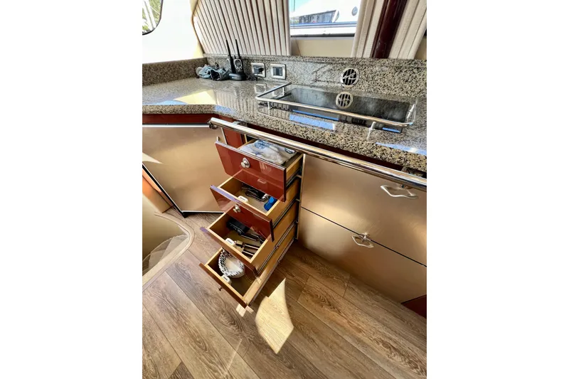 Slide: The Image of Luxurious 2007 Sea Ray 58 Sedan Bridge yacht kitchen with granite countertops and open drawers. - 93