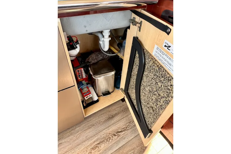 Slide: The Image of Open cabinet under sink in 2007 Sea Ray 58 Sedan Bridge yacht kitchen. - 95