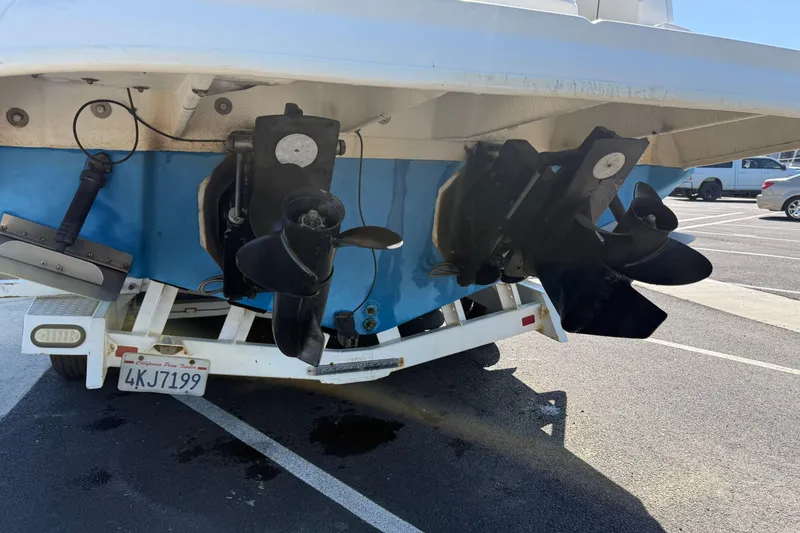 Slide: The Image of 2005 Sea Ray Sundancer 280 boat on trailer, showing dual propellers in parking lot. - 16