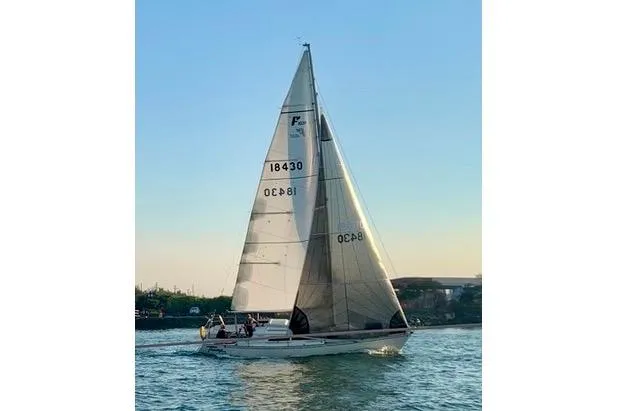 Slide: The Image of Sailing yacht Farr 1020, 1986 model, gliding on calm waters at sunset. - 4