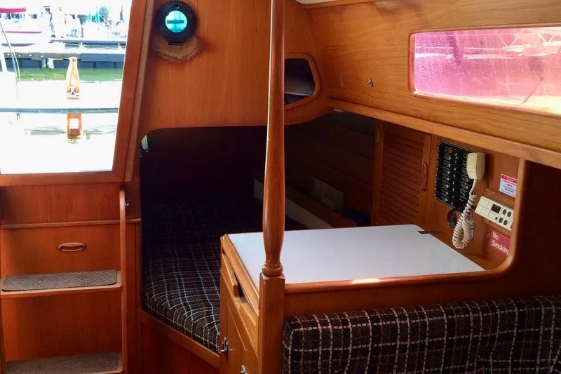 Slide: The Image of Interior of a 1986 Farr 1020 sailboat with wooden furnishings and cozy cabin space. - 6