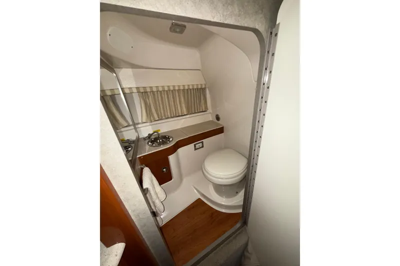 Slide: The Image of 2009 Formula 310 Sun Sport boat bathroom with sink, toilet, and wooden flooring. - 14