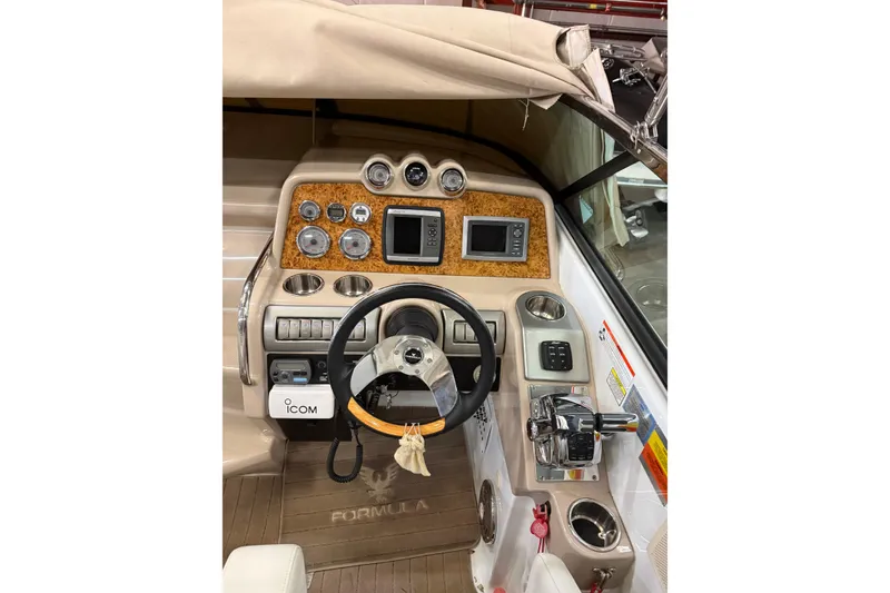 Slide: The Image of 2009 Formula 310 Sun Sport boat dashboard with steering wheel and control panel. - 6