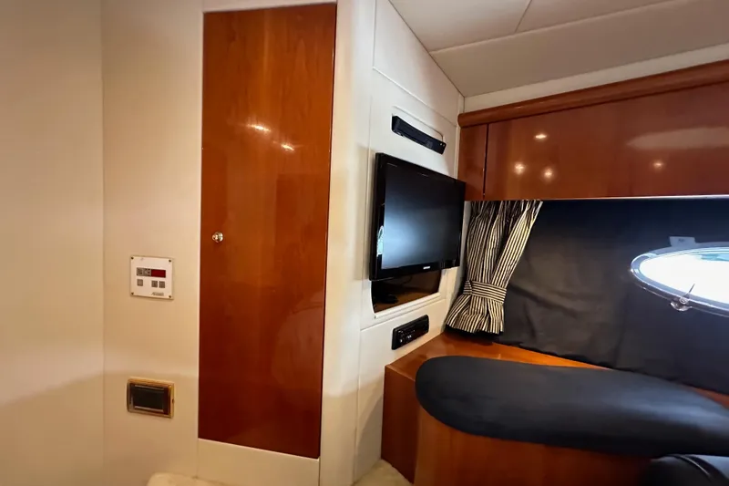 Slide: The Image of Interior of 2000 Sunseeker Predator 60 yacht with TV, wood paneling, and porthole. - 100