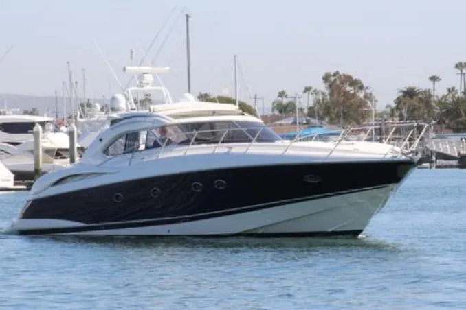 Slide: The Image of Sunseeker Predator 60 yacht, 2000 model, cruising in a marina with other boats. - 3