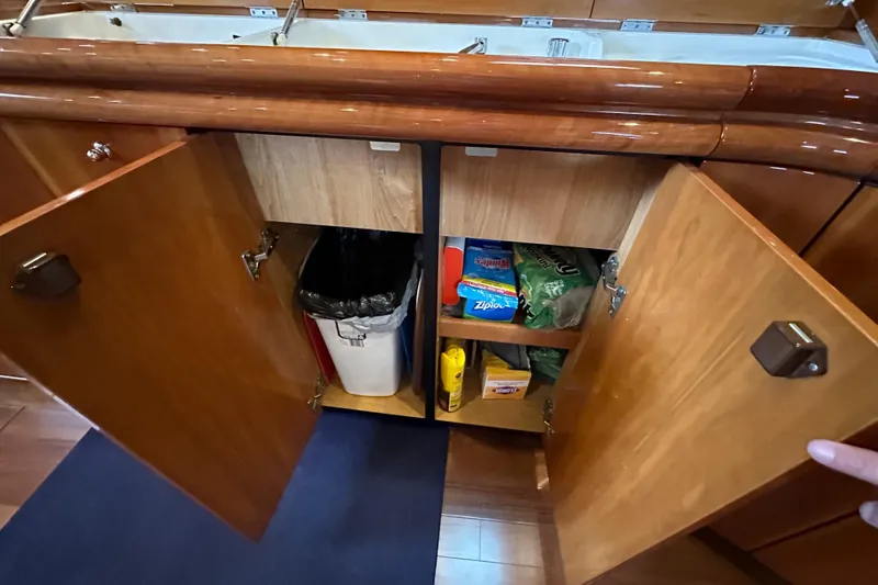 Slide: The Image of Open wooden cabinets in Sunseeker Predator 60 yacht kitchen, showcasing storage space and supplies. - 87