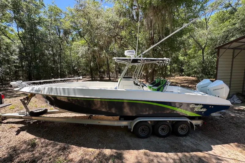 The Image of 2000 Fountain 31 Tournament Edition boat on trailer in wooded area. - 1