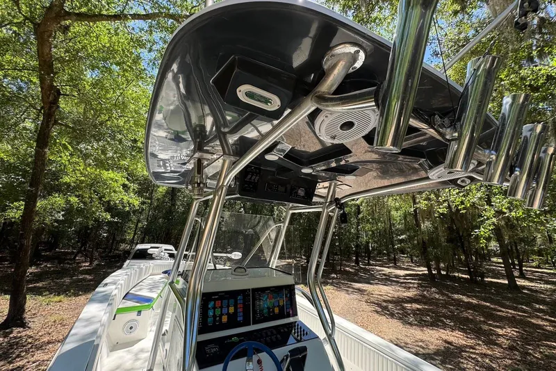 Slide: The Image of 2000 Fountain 31 Tournament Edition boat interior with advanced controls and rod holders in a wooded setting. - 16