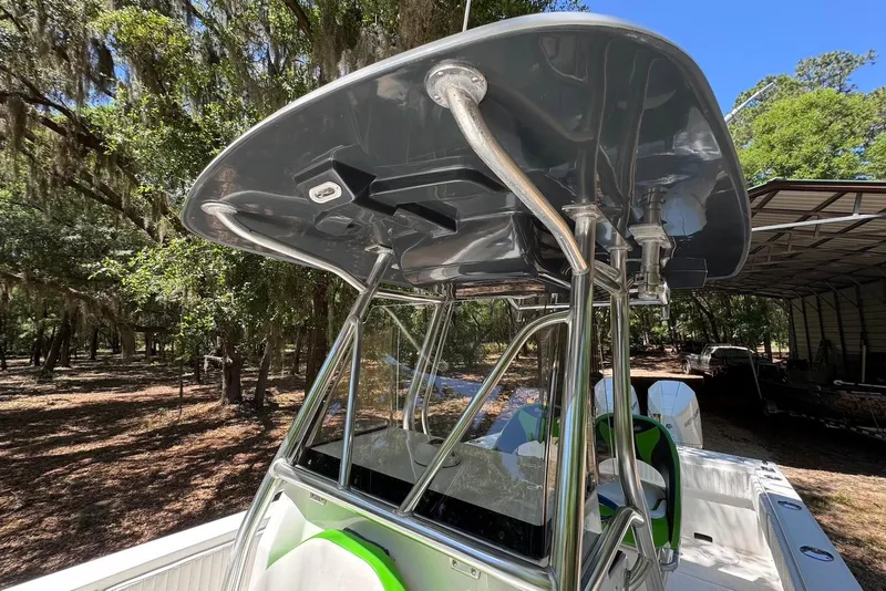 Slide: The Image of 2000 Fountain 31 Tournament Edition boat with T-top, parked outdoors under trees. - 17