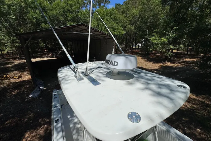 Slide: The Image of 2000 Fountain 31 Tournament Edition boat with radar, parked near trees. - 18