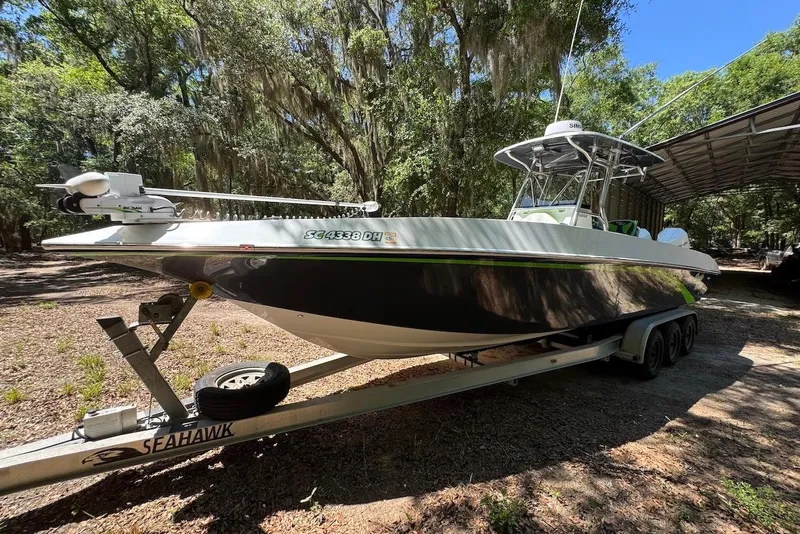 Slide: The Image of 2000 Fountain 31 Tournament Edition boat on trailer in wooded area. - 2