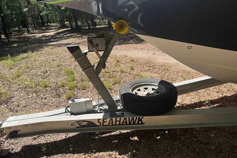 Slide: The Image of Trailer for 2000 Fountain 31 Tournament Edition boat with spare tire in wooded area. - 23