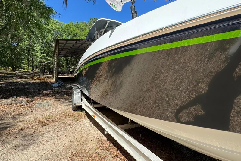 Slide: The Image of 2000 Fountain 31 Tournament Edition boat on trailer under a canopy in wooded area. - 24