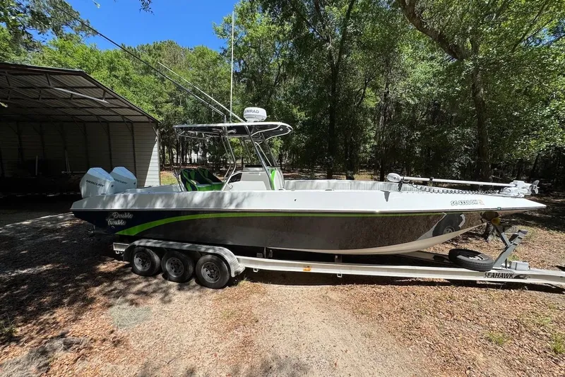 Slide: The Image of 2000 Fountain 31 Tournament Edition boat on trailer in wooded area. - 4