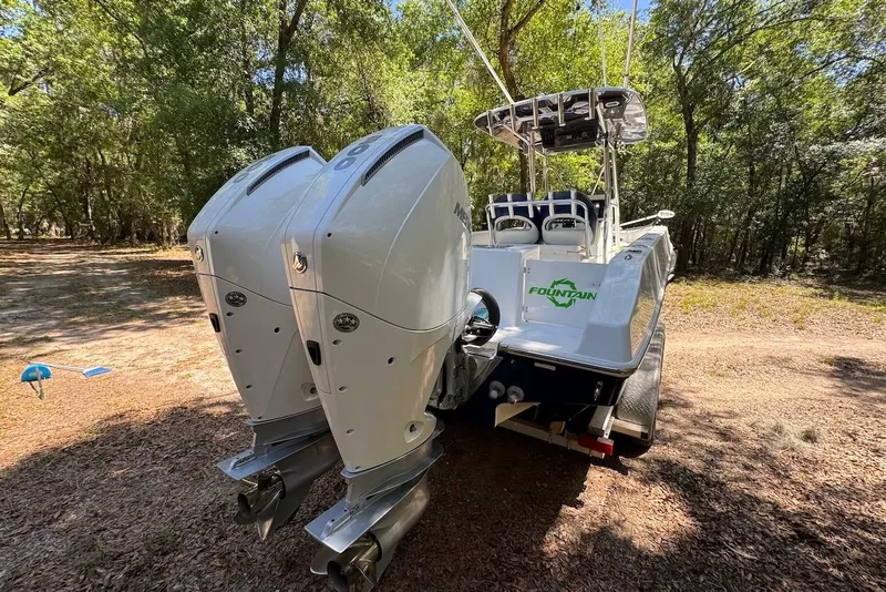 Slide: The Image of 2000 Fountain 31 Tournament Edition boat with dual outboard motors in a wooded area. - 5