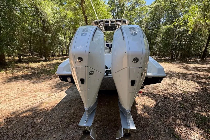 Slide: The Image of 2000 Fountain 31 Tournament Edition boat with dual outboard engines in a wooded area. - 6