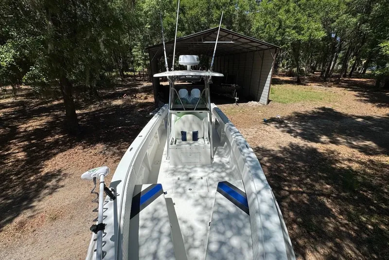 Slide: The Image of 2000 Fountain 31 Tournament Edition boat in wooded area near a metal shed. - 8