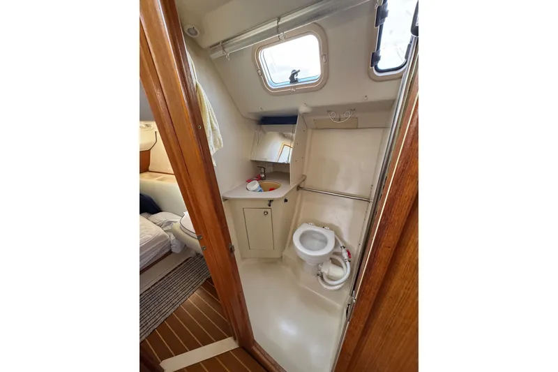 Slide: The Image of 2002 Hunter 410 yacht bathroom with toilet, sink, and window. - 10