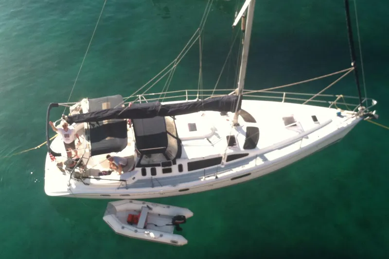 Slide: The Image of Aerial view of 2002 Hunter 410 sailboat with dinghy on clear water. - 2