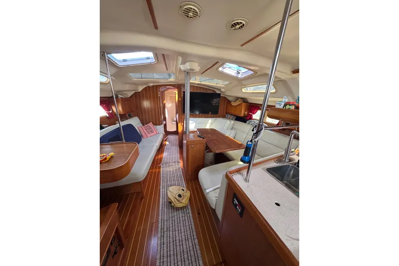 Slide: The Image of Interior of 2002 Hunter 410 sailboat with cozy seating and wooden finishes. - 4