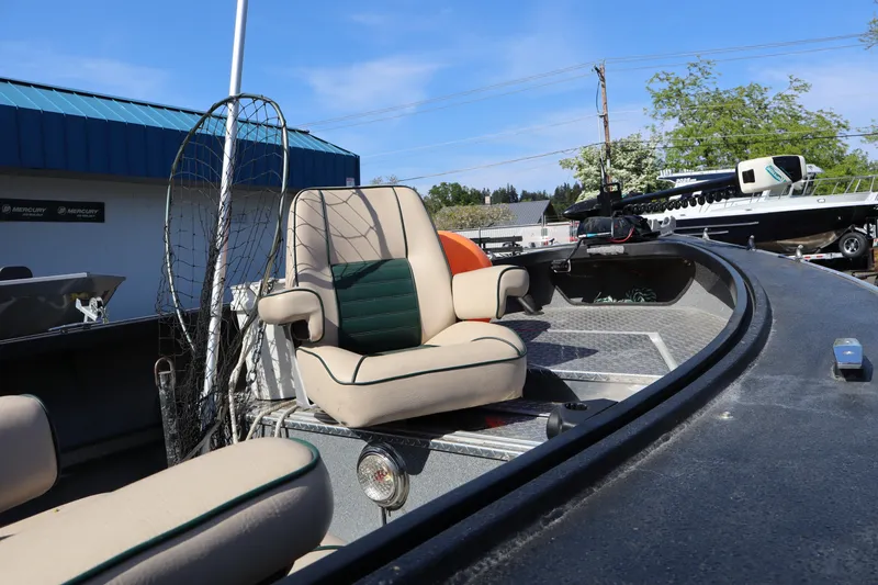 Slide: The Image of 1997 Willie Boats Predator with cushioned seats and fishing gear, parked outdoors. - 14