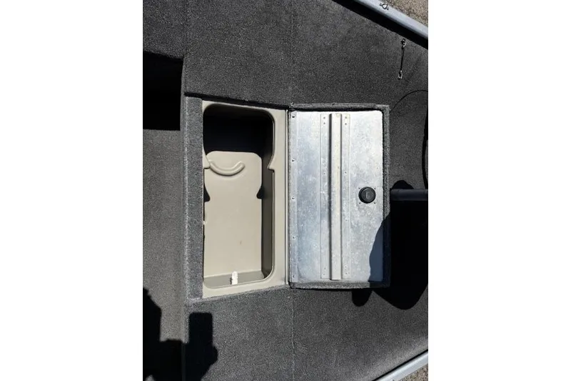 Slide: The Image of 2014 Tracker Pro 170 boat storage compartment with metal lid and carpeted surface. - 12