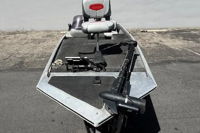 Slide: The Image of 2014 Tracker Pro 170 fishing boat with seating and trolling motor on pavement. - 24