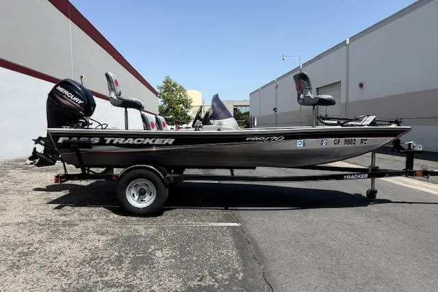 Slide: The Image of 2014 Tracker Pro 170 boat on trailer, parked outdoors near industrial buildings. - 9