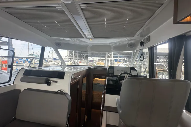 Slide: The Image of Interior view of 2023 Beneteau Antares 11 Coupe, featuring helm and seating area. - 12