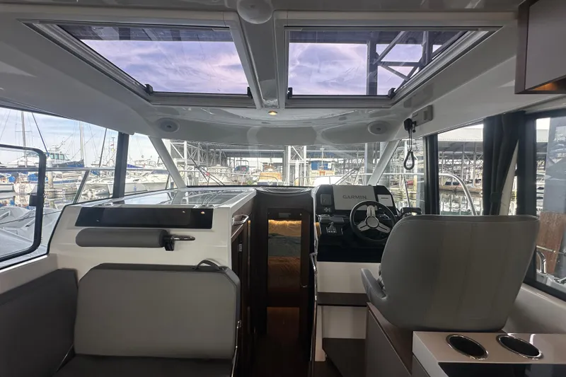 Slide: The Image of Interior of 2023 Beneteau Antares 11 Coupe with helm and seating area. - 13